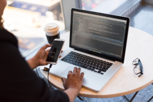 a person using a mobile phone and a laptop